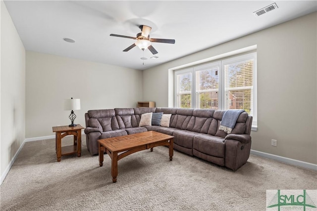living room with visible vents, baseboards, ceiling fan, and light colored carpet
