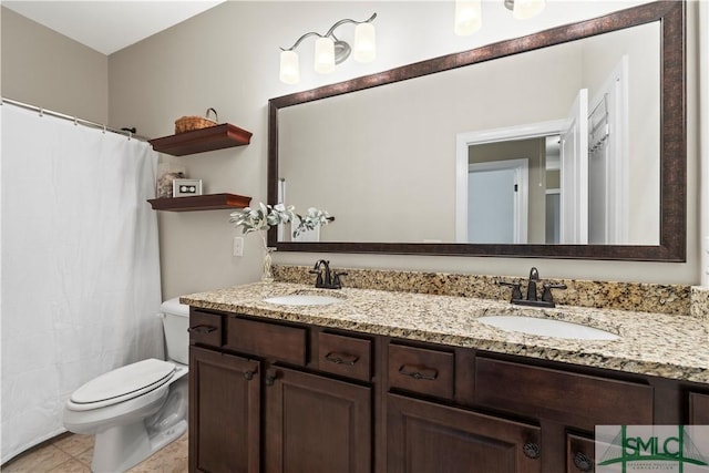 full bathroom with a sink, toilet, and double vanity