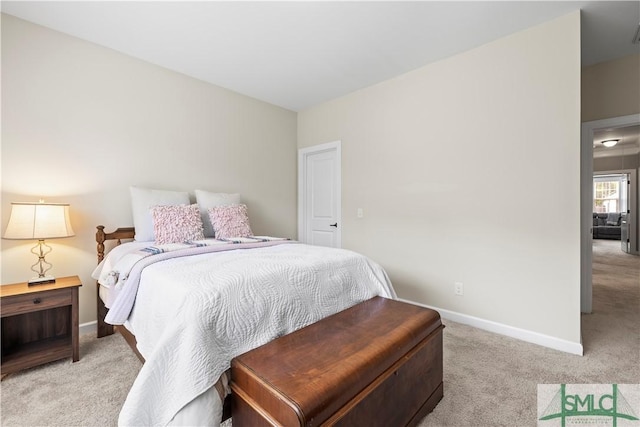 bedroom with light colored carpet and baseboards