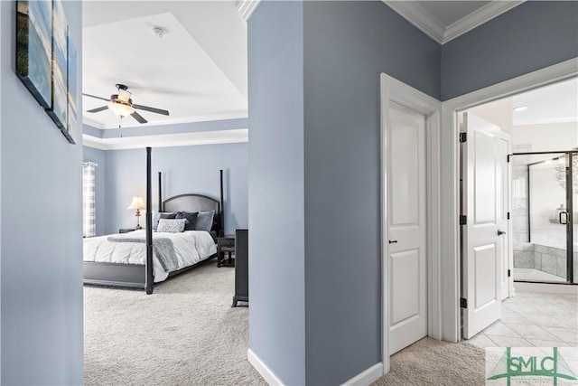 carpeted bedroom with baseboards, ornamental molding, a ceiling fan, and ensuite bath