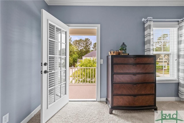 entryway featuring crown molding, baseboards, and carpet