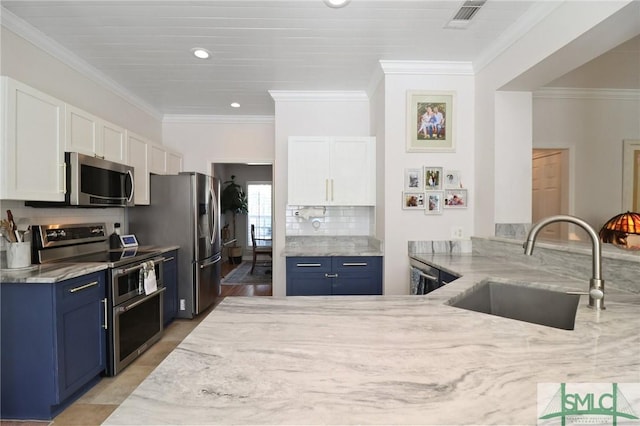 kitchen with a sink, appliances with stainless steel finishes, light stone countertops, and blue cabinets