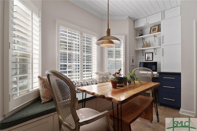 dining room featuring light tile patterned floors and crown molding