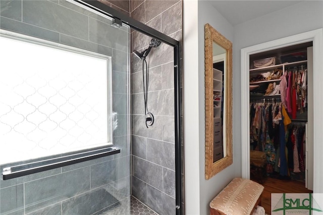 full bathroom featuring a spacious closet and a shower stall
