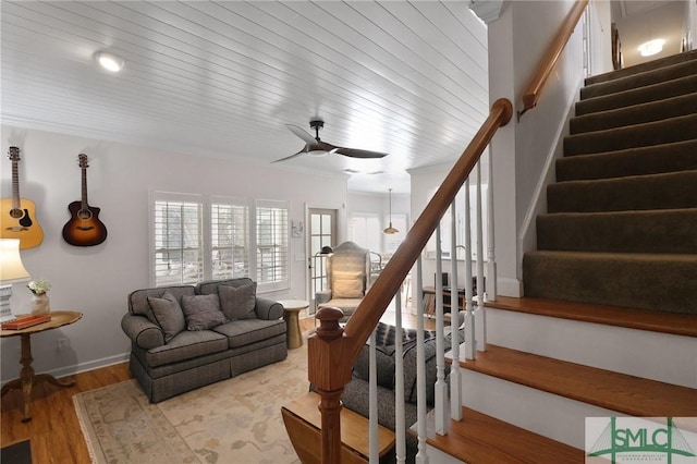 stairway with ceiling fan and wood finished floors