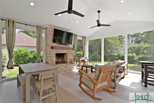 sunroom / solarium with lofted ceiling with beams, a wealth of natural light, and wood finished floors