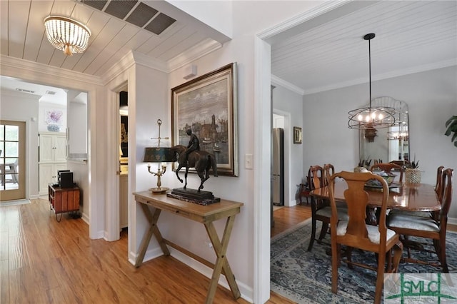 dining space featuring visible vents, light wood-type flooring, and a chandelier