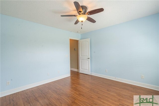 spare room with baseboards, ceiling fan, and wood finished floors