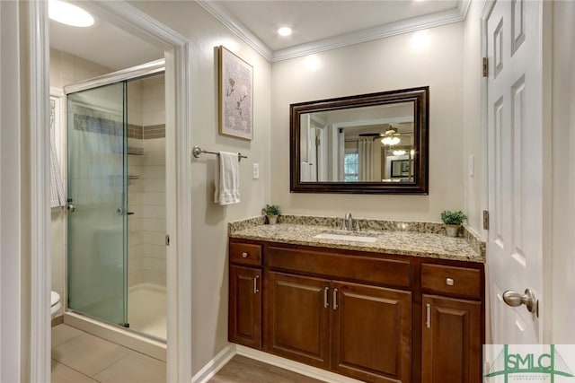 full bathroom with crown molding, baseboards, a stall shower, and vanity