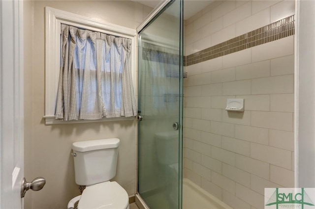 bathroom featuring toilet and a stall shower