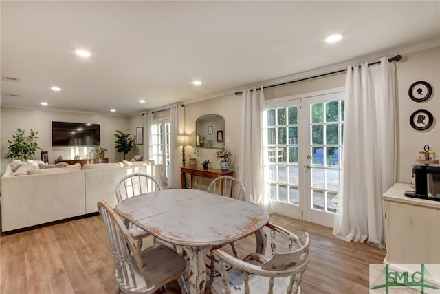 dining room with crown molding, recessed lighting, french doors, and light wood-type flooring