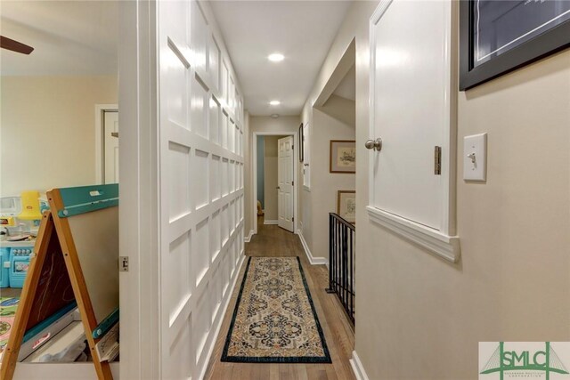 hallway featuring recessed lighting, baseboards, and wood finished floors