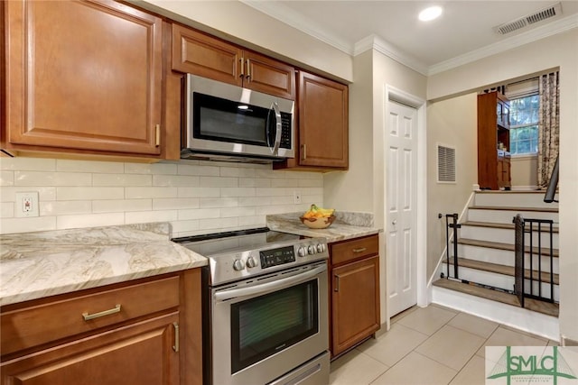 kitchen with light tile patterned flooring, appliances with stainless steel finishes, visible vents, and tasteful backsplash