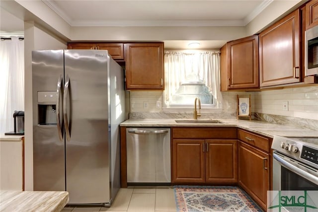 kitchen featuring a sink, tasteful backsplash, stainless steel appliances, and brown cabinets