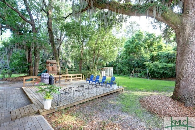 view of yard featuring a deck and a playground
