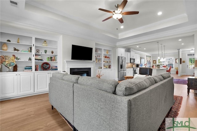 631 Blue Moon Xing, Pooler, GA 31322 - living area with a ceiling fan, visible vents, crown molding, a tray ceiling, and light wood-style flooring