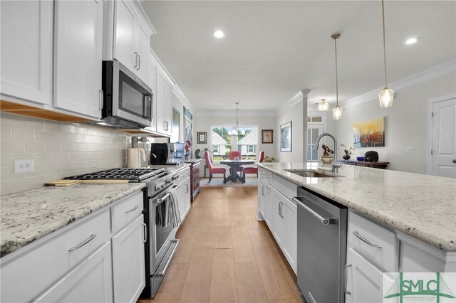 631 Blue Moon Xing, Pooler, GA 31322 - kitchen featuring a sink, stainless steel appliances, white cabinetry, decorative backsplash, and ornamental molding