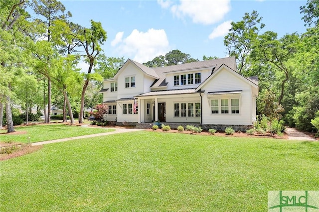 view of front of property featuring a porch, metal roof, a front yard, and a standing seam roof