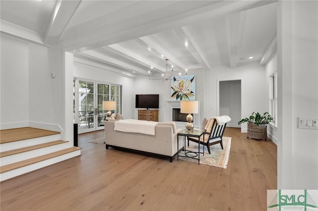 living area with wood finished floors, recessed lighting, beamed ceiling, a chandelier, and stairs