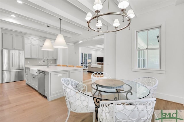interior space featuring light countertops, a chandelier, a sink, appliances with stainless steel finishes, and a wealth of natural light