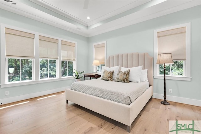 bedroom with crown molding, baseboards, visible vents, and wood finished floors