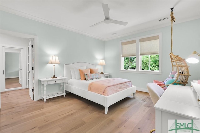 bedroom featuring crown molding, a ceiling fan, visible vents, and light wood-style flooring