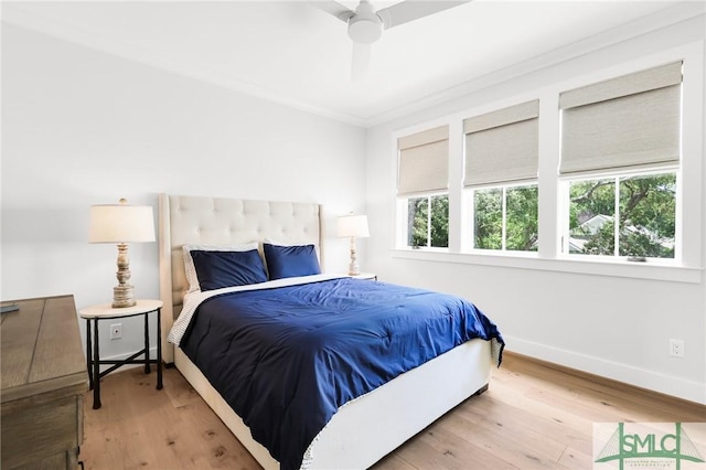 bedroom with crown molding, baseboards, ceiling fan, and wood finished floors