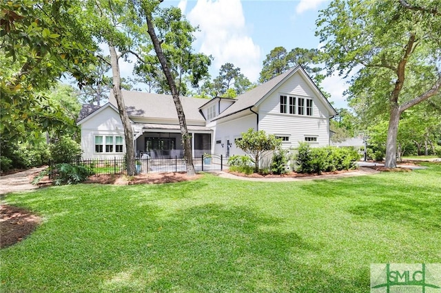 back of house with a lawn and fence