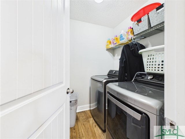 1246 Cypress Fall Cir, Hinesville, GA 31313 - laundry room with laundry area, a textured ceiling, washing machine and clothes dryer, baseboards, and light wood finished floors