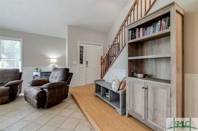 178 Country Way, Springfield, GA 31329 - living area featuring stairs, a decorative wall, light tile patterned floors, and a wainscoted wall