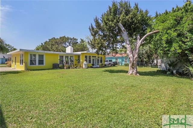 1508 Miller Ave, Tybee Island, GA 31328 - view of front of house with cooling unit, a chimney, and a front yard