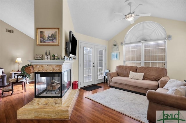 living area with a ceiling fan, vaulted ceiling, french doors, and visible vents