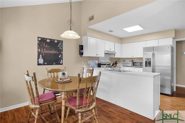 kitchen featuring appliances with stainless steel finishes, a sink, a peninsula, baseboards, and visible vents