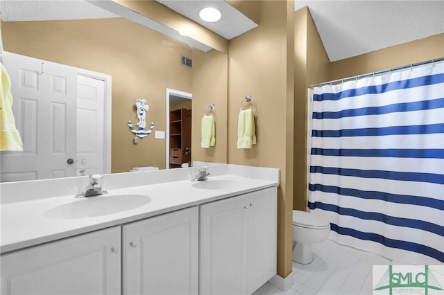 full bathroom with double vanity, toilet, a sink, and lofted ceiling