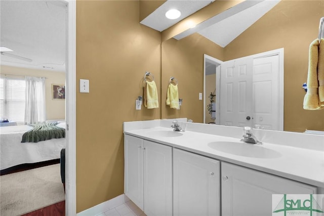 bathroom featuring a sink, lofted ceiling, double vanity, and connected bathroom