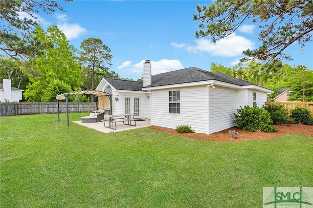 rear view of house featuring a patio, a fenced backyard, a lawn, and french doors