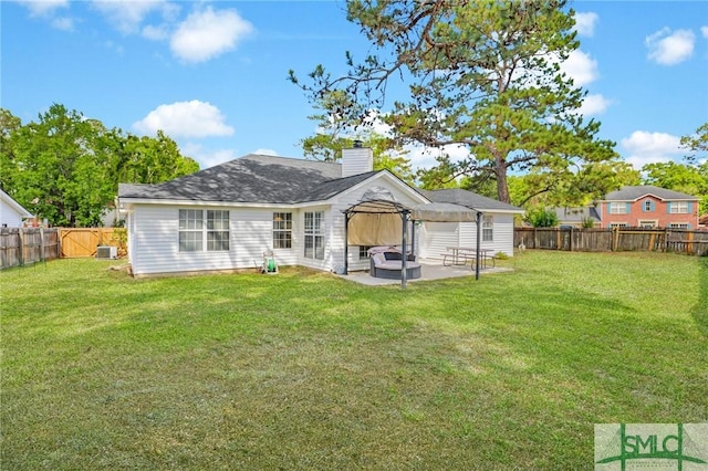 rear view of house with a lawn, a fenced backyard, a patio area, and a chimney