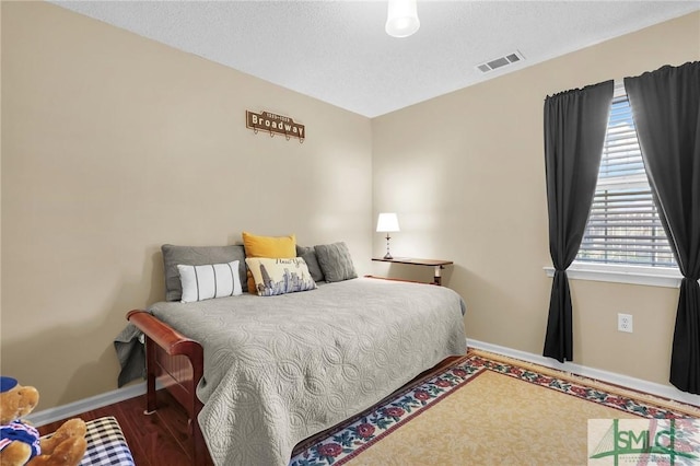bedroom with baseboards and visible vents