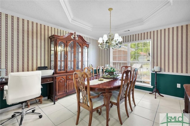 dining room with a textured ceiling, visible vents, ornamental molding, and a raised ceiling