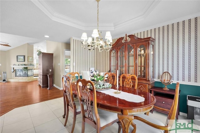 dining area with an inviting chandelier, crown molding, radiator heating unit, and a tray ceiling