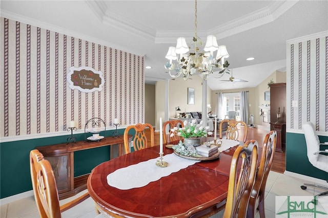 tiled dining area featuring ceiling fan with notable chandelier, baseboards, ornamental molding, and a tray ceiling