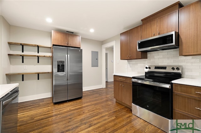 kitchen featuring light countertops, backsplash, appliances with stainless steel finishes, and dark wood-style floors