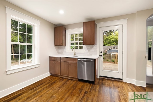 interior space featuring dark wood finished floors, dishwasher, a sink, baseboards, and light countertops