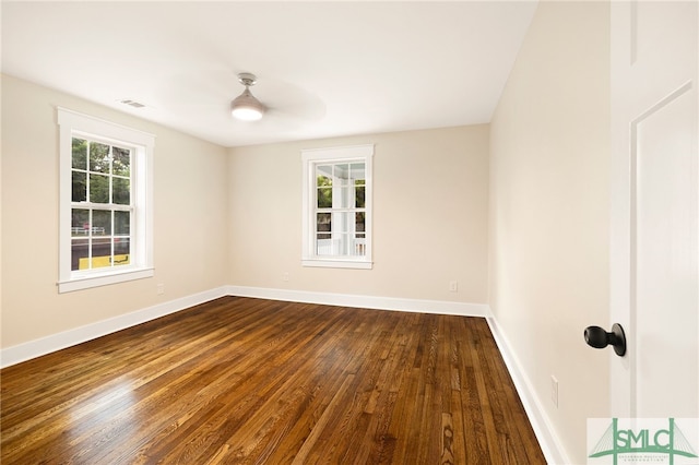 spare room with baseboards, dark wood finished floors, and visible vents