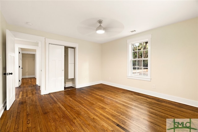 unfurnished bedroom featuring a ceiling fan, baseboards, visible vents, and dark wood-type flooring