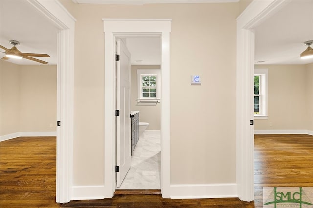 hallway featuring baseboards and wood finished floors