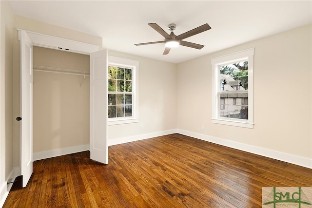 unfurnished bedroom with dark wood-type flooring, a ceiling fan, baseboards, and a closet