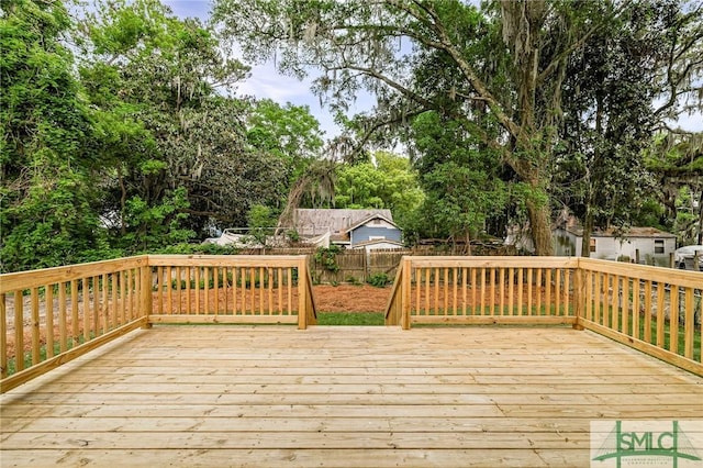 wooden terrace with a fenced backyard