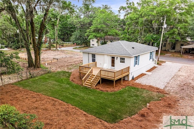 back of property featuring a lawn, a wooden deck, stairs, and roof with shingles