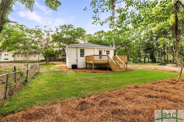 back of property with fence, a yard, a wooden deck, and stairs
